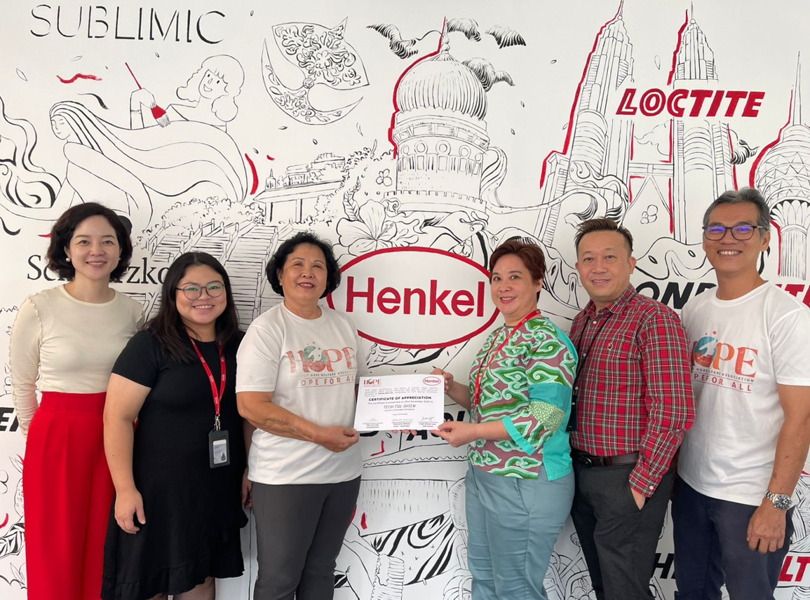 Ms. Lai Leen, Chairperson of Project Hope Welfare Association (center left), presents the certificate of appreciation to Ms. Teoh Tsu-Shien, President of Henkel Malaysia (center right).