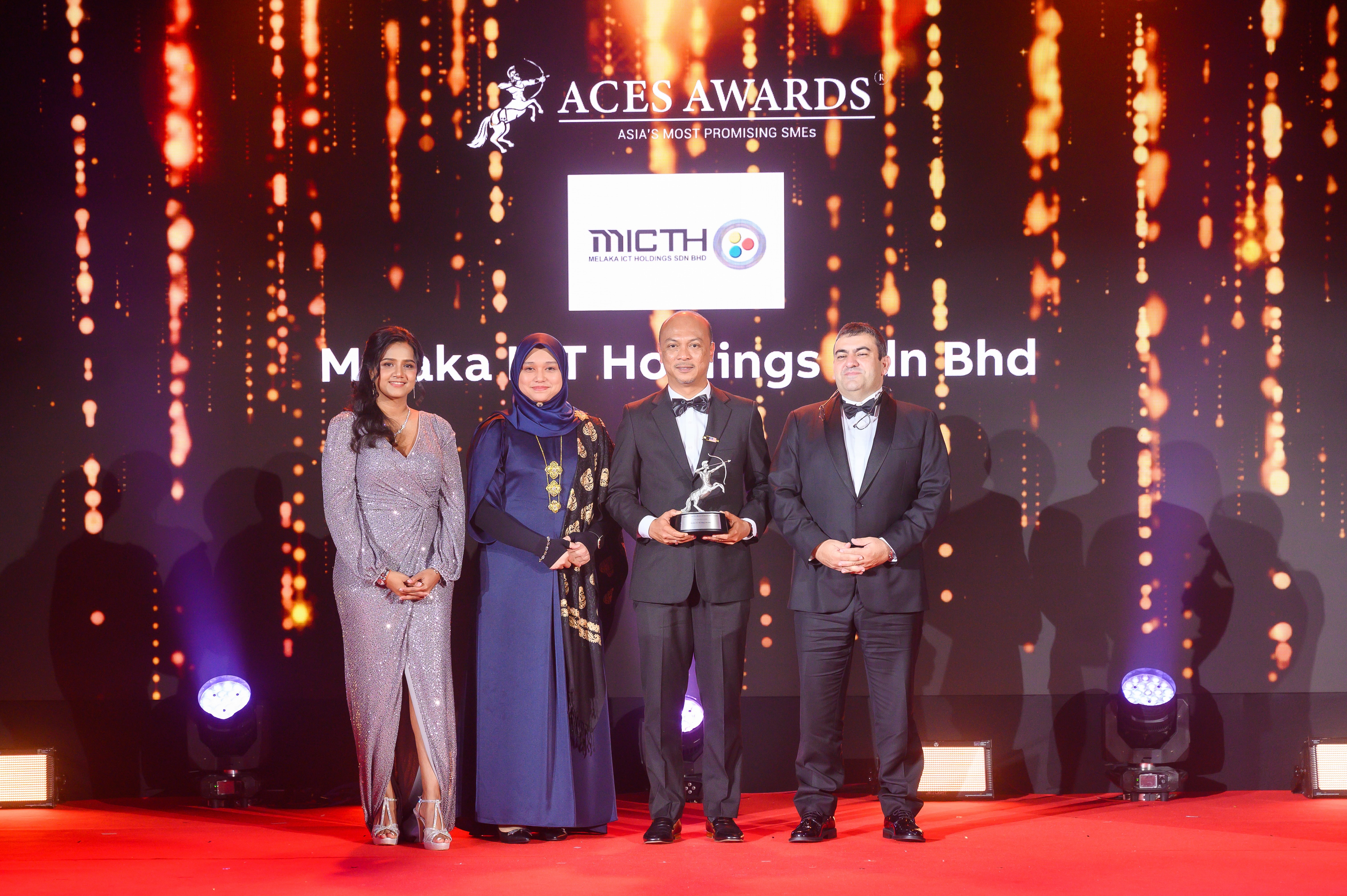 Dr. Nazdiana Ab Wahab, Chief Executive Officer of Melaka ICT Holdings Sdn Bhd (left center), and YB Datuk Fairul Nizam bin Roslan, Deputy Chairman of the Board of Directors (right center), proudly receive the Asia